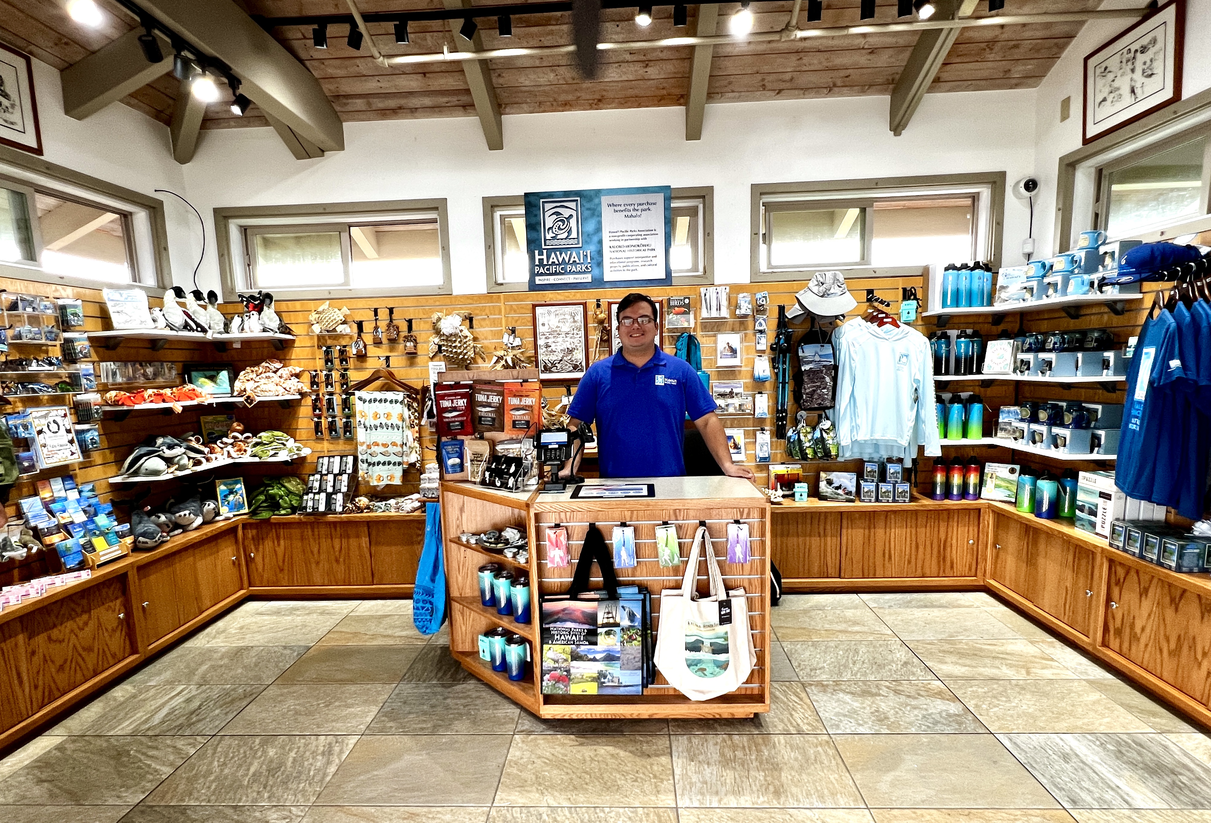 An HPPA frontline staff member stands behind the desk at the KAHO park store.